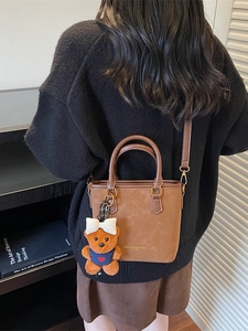 Vintage brown leather tote bag with cute bear charm and adjustable crossbody strap