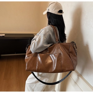 Sac de voyage en similicuir marron avec grande poche avant et bandoulière réglable