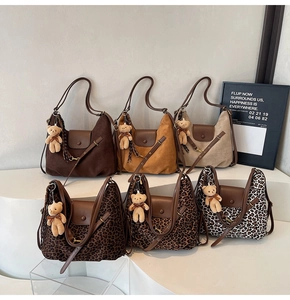 Detail view of multi-color tote bags with leopard print patterns and plush bear charms
