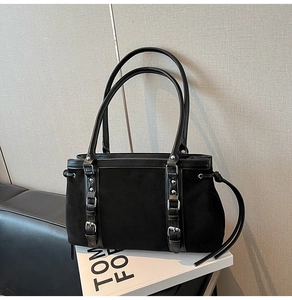 Detail of vintage suede shoulder bag with silver studs and buckle strap accents