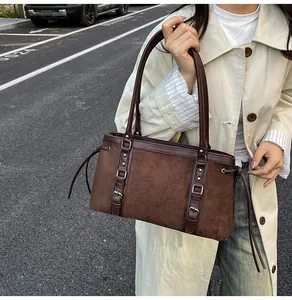 Street style view of deep brown suede tote bag with metal buckles and drawstring detail