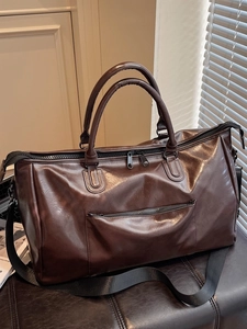 Grand sac de voyage en similicuir marron foncé sur banc pour sport ou voyages de week-end