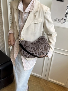 Sac croissant en peluche léopard avec chaîne argentée porté par une femme chic