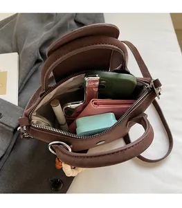 Spacious interior of a dark brown matte leather handbag showing daily essentials storage