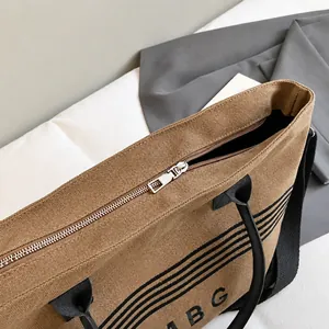 Close-up of durable silver metal zipper closure on striped canvas tote bag detail
