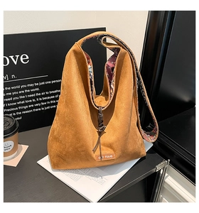 Close-up of brown suede hobo bag with our fave leather label and floral lining