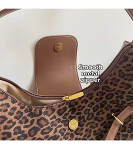Close-up of leopard print tote featuring smooth gold zipper and quality leather edges