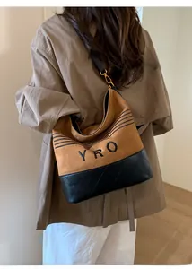 Detail of hobo bucket bag with YRO logo, suede material and quilted leather base