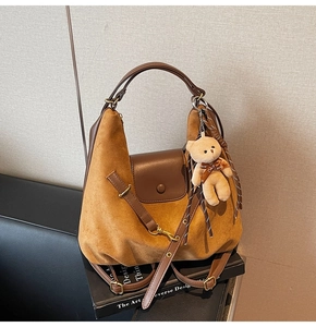 Detail of vintage leopard tote bag in brown suede with decorative teddy bear charm