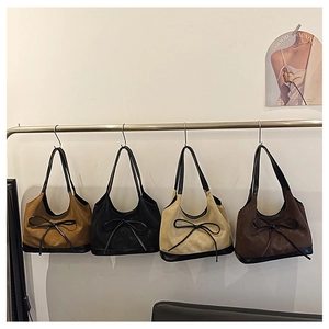 Selection of four suede shoulder bags in caramel, black, beige, and coffee with bow details