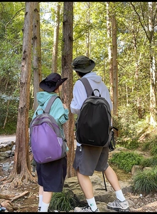 Close-up of durable purple outdoor backpack with padded straps in a forest setting