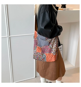 Detail of a large canvas tote bag with mixed patchwork patterns in a stylish street look