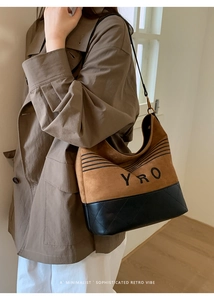 Detail of the YRO embroidered lettering on a vintage brown suede and black quilted hobo bag