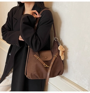 Close-up of leopard print suede shoulder bag with magnetic flap and cute bear pendant