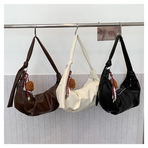Detail view of leather hobo bags with pleated texture, wide straps and plush bear charms