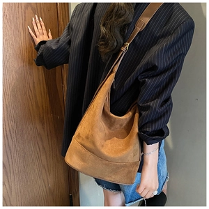 Detailed side view of large caramel suede hobo bag with adjustable shoulder strap