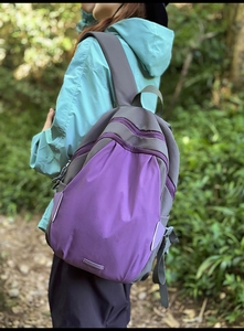 Side view of outdoor hiking backpack with purple and grey color contrast on female model