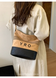 Detail view of the brown suede and black leather patchwork tote with quilted stitching