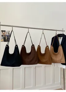 Multiple colors of large suede tote bags displayed on a rack for retro casual style