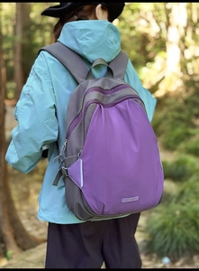 Detail of color-block backpack in grey and purple waterproof nylon for outdoor travel