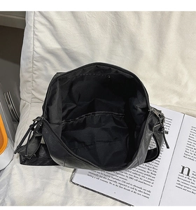 Vue détaillée du grand compartiment intérieur et de la fermeture à franges du sac noir