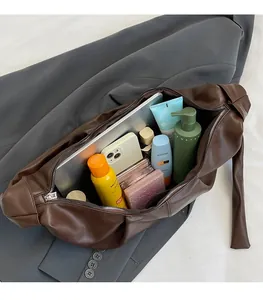 Detail showing the large storage capacity of a brown pleated tote bag with essentials