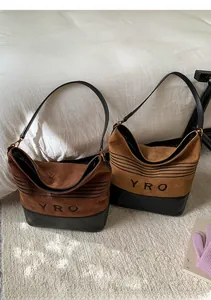 Detail of vintage suede bucket bags in brown and coffee with quilted leather base