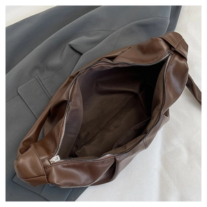 Close-up of the zipper closure and spacious brown interior of this chic shoulder bag