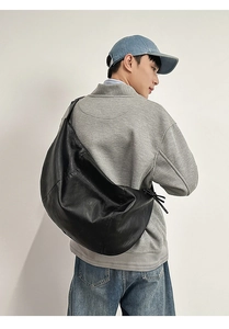 Détail du grand sac besace noir porté par une personne pour montrer la taille réelle