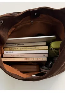 Interior view of brown suede bucket bag showing large capacity for books and tablet