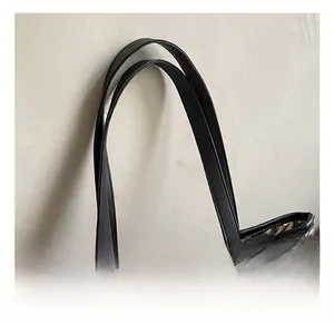 Detail showing high-quality black leather handles with cross stitching on champagne tote