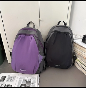 Close-up of contrast color backpacks in purple and black with buckle details