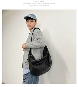 Vue détaillée du sac bandoulière noir en forme de croissant avec sangle large et zip