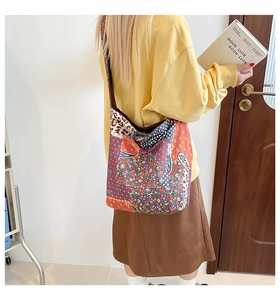 Detail view of large boho patchwork tote bag with floral and leopard prints on a model