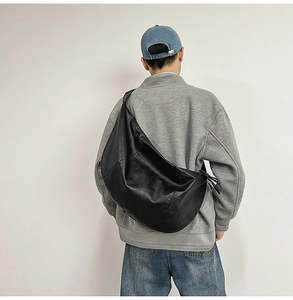 Détail du grand sac à bandoulière noir en forme de demi-lune avec fermeture à glissière