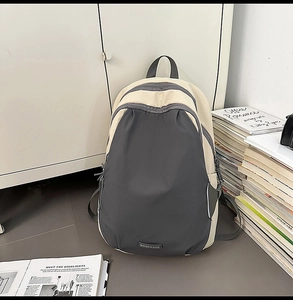 Detail view of contrast color backpack showing the large main pocket and front curved pouch