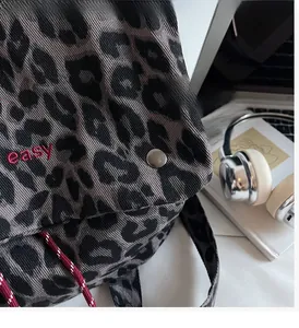 Close-up of leopard print backpack with easy embroidery and metallic silver button detail