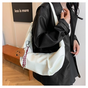 Close-up of white crescent cloud shoulder bag featuring pleated leather and teddy charm