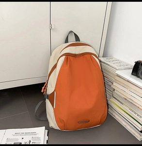 Detail of color-block canvas backpack with brand label and side buckle in a lifestyle setting