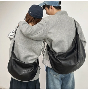 Vue arrière d'un couple portant de grands sacs bandoulière en cuir noir en croissant