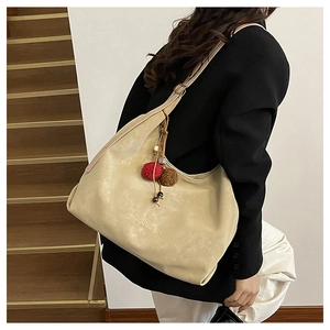 Vue détaillée du grand sac cabas en suédine beige avec pompon décoratif et perles
