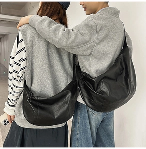 Sac bandoulière unisexe noir en forme de demi-lune avec texture litchi sur modèles homme et femme