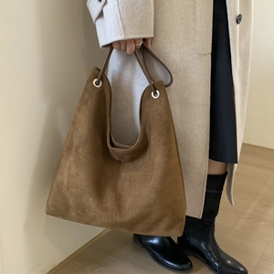 Detail of a large dark brown suede tote bag styled with a minimalist autumn outfit