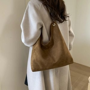 Brown suede tote bag with metal eyelet detail shown on model for daily commuting fashion