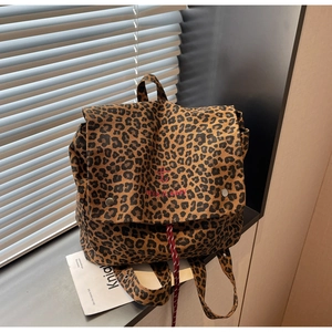 Close-up of leopard print canvas backpack with red 'take it easy' embroidery and drawstring