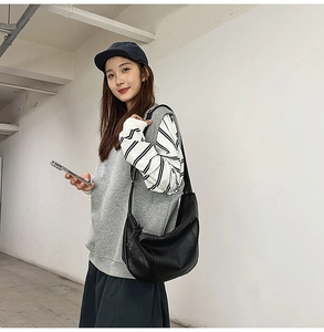 Vue détaillée du grand sac hobo en cuir noir porté par un mannequin pour le travail