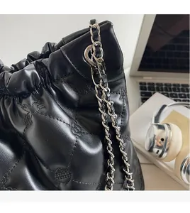 Vue détaillée du sac seau noir en cuir matelassé avec bandoulière en chaîne argentée