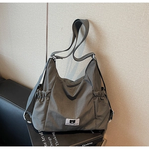 Dettaglio della tasca laterale in nylon grigio antracite con chiusura elastica e logo