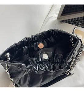 Détail intérieur du sac matelassé noir avec fermoir magnétique et chaîne argentée