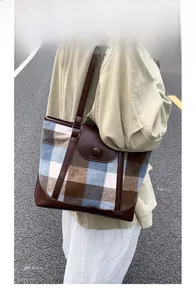 Detail of vintage plaid tote bag featuring brown leather trim and button closure